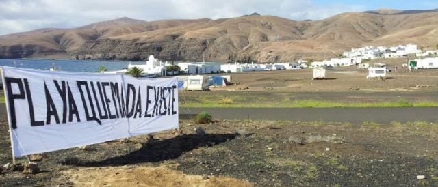 Los vecinos de Playa Quemada despliegan una pancarta de seis metros a la entrada del pueblo y reclaman a la alcaldesa que frene el Plan General