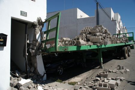 La carga de un camión de cemento arrolla una casa y tres coches en Arrecife
