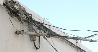 Los vecinos de la calle José Antonio se quejan del peligro de un poste de luz "colgante"