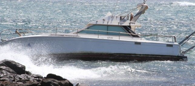 Uno de los barcos fondeados frente al Ayuntamiento de Arrecife acaba encallado en las rocas
