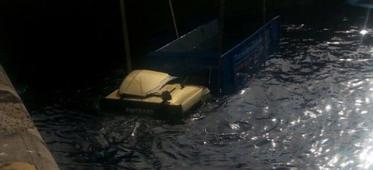 Un camión encargado de recoger la basura de los barcos se cae al agua en Los Mármoles