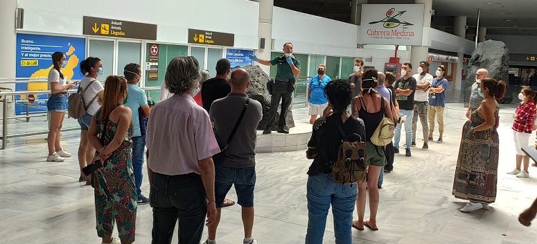A Civil Guard officer informing people waiting for passengers on the flight in which a person with Covid-19 arrived