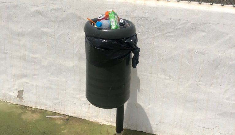 Papelera llena de basura en la cancha deportiva de Mancha Blanca