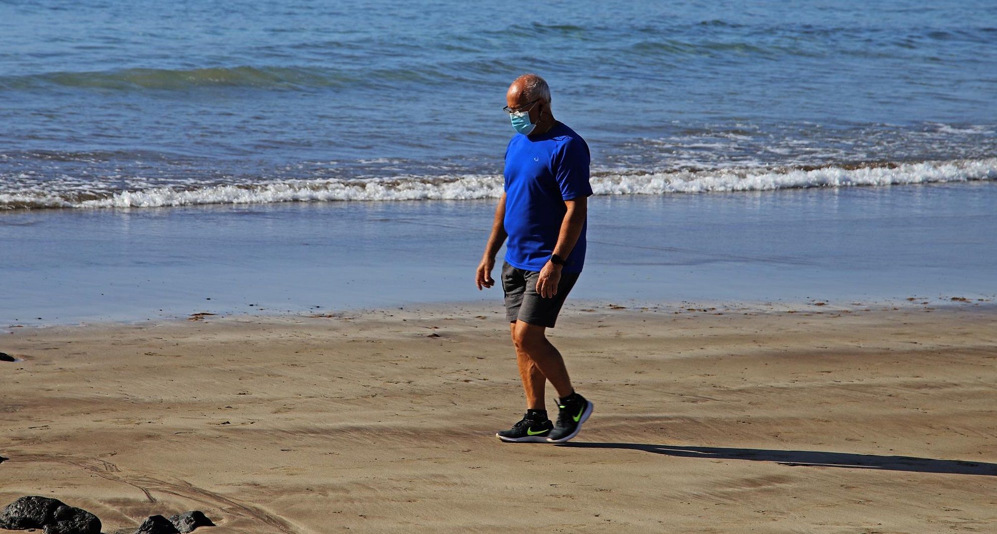 A man walks with a mask on the beach during the coronavirus crisis in Lanzarote