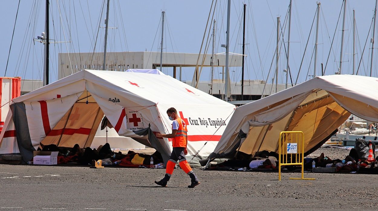 Inmigrantes tumbados en el suelo bajo las carpas instaladas por Cruz Roja en el puerto de Arrecife