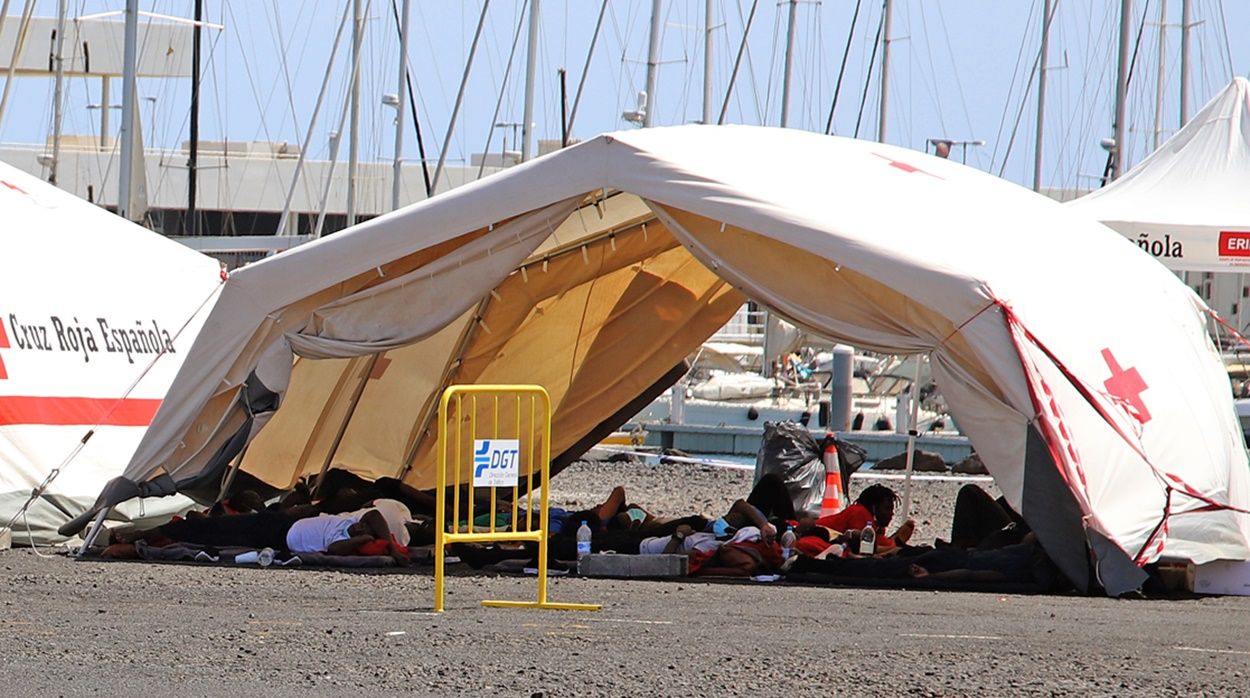 Inmigrantes de la patera rescatada el lunes tumbados en el suelo en Puerto Naos