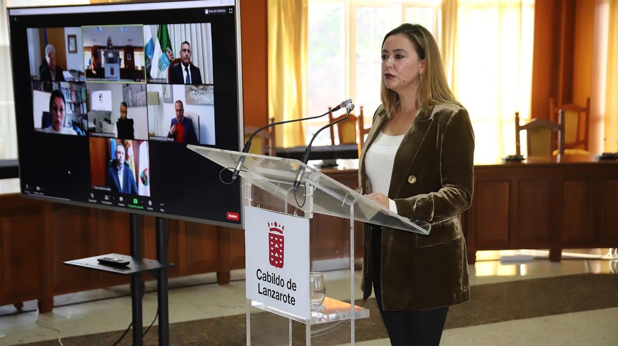 María Dolores Corujo, durante la rueda de prensa, con lo siete alcaldes conectados a la misma