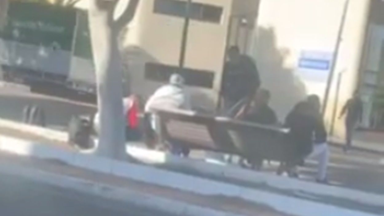 People smoking and drinking without a mask on a bench in the Medular of Arrecife