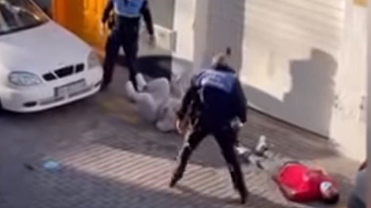 Imagen donde se ve al hombre que fue golpeado por la Policía, aparentemente inconsciente en el suelo