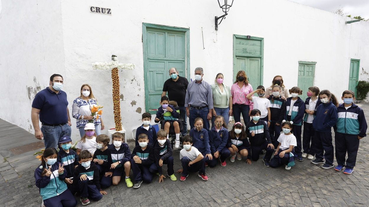 School children who have adorned the crosses of Teguise with flowers
