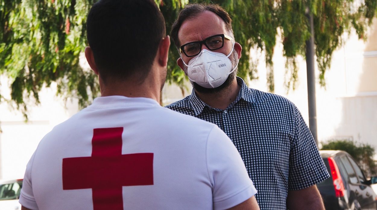 El consejero de Podemos, Jorge Peñas, con un miembro de Cruz Roja
