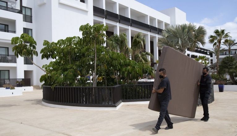 Trabajadores del hotel trasladando un colchón Trabajadores del hotel trasladando un colchón