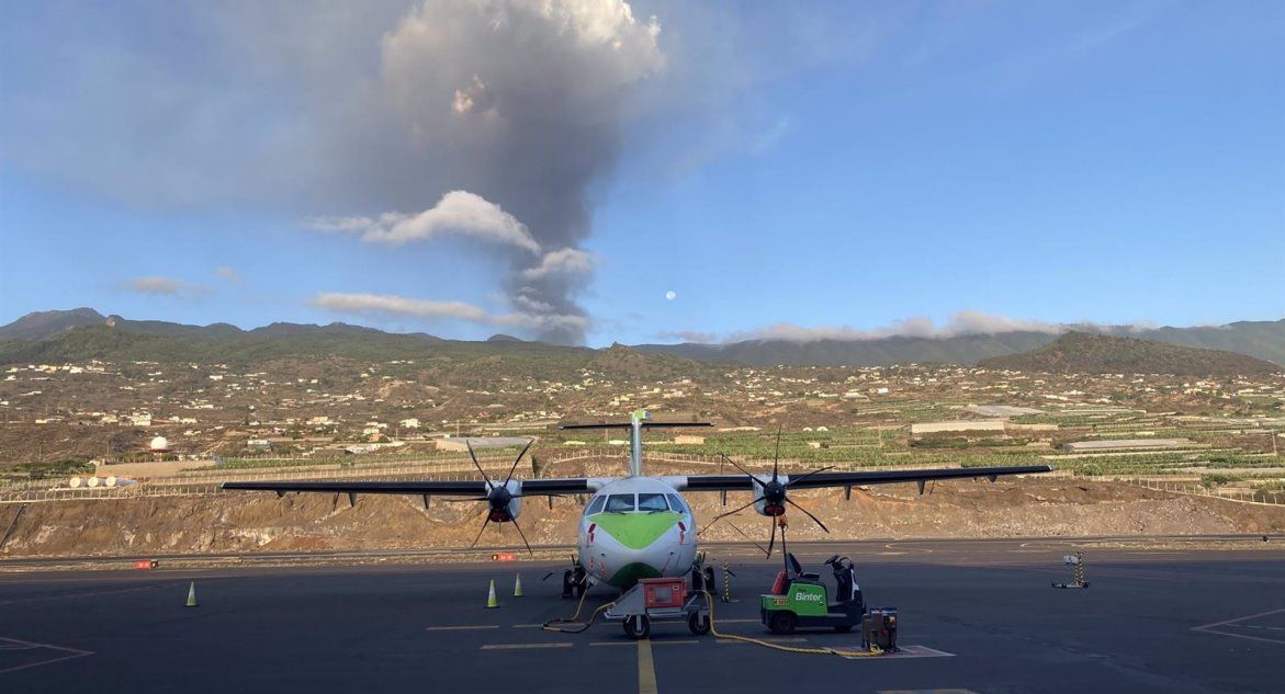 Un avión de Binter en la pista del aeropuerto de La Palma, con el volcán en erupción al fondo