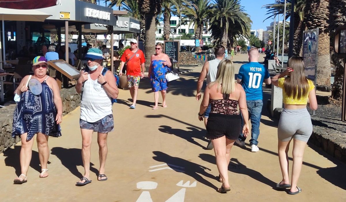 Turistas paseando en la playa de Las Cucharas de Costa Teguise