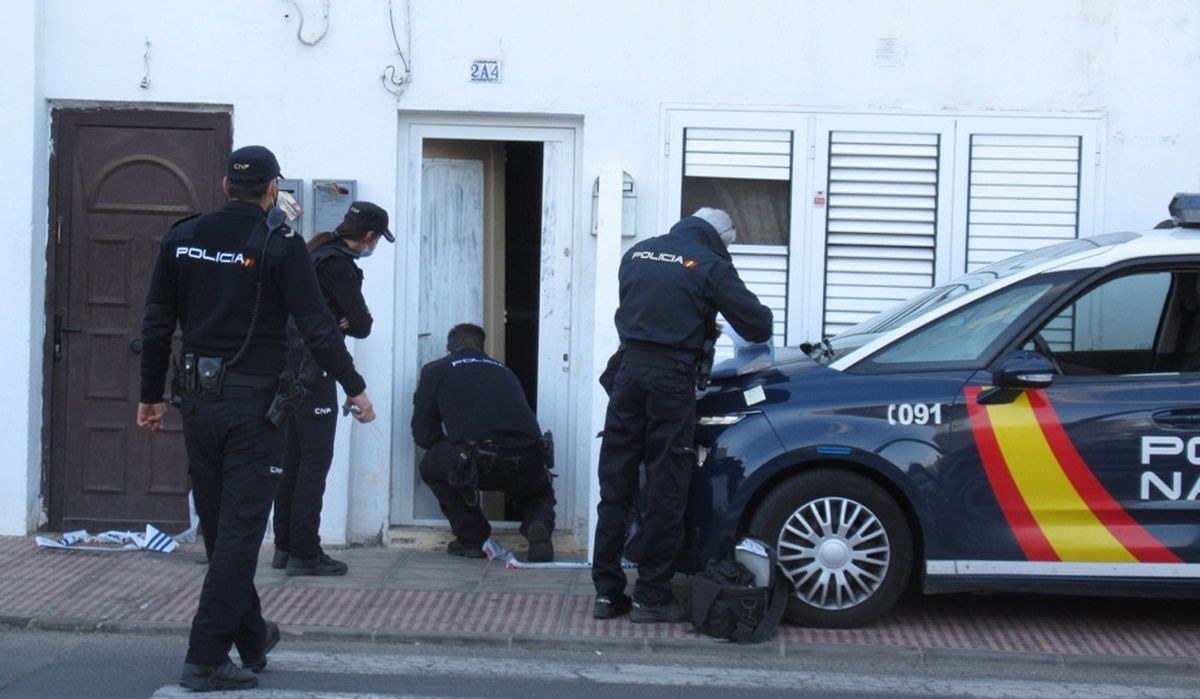 Policías investigando la entrada de la vivienda