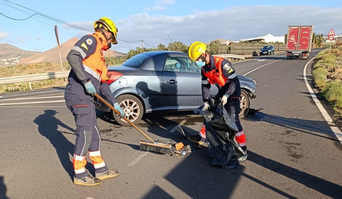 Bomberos limpiando la calzada en el accidente