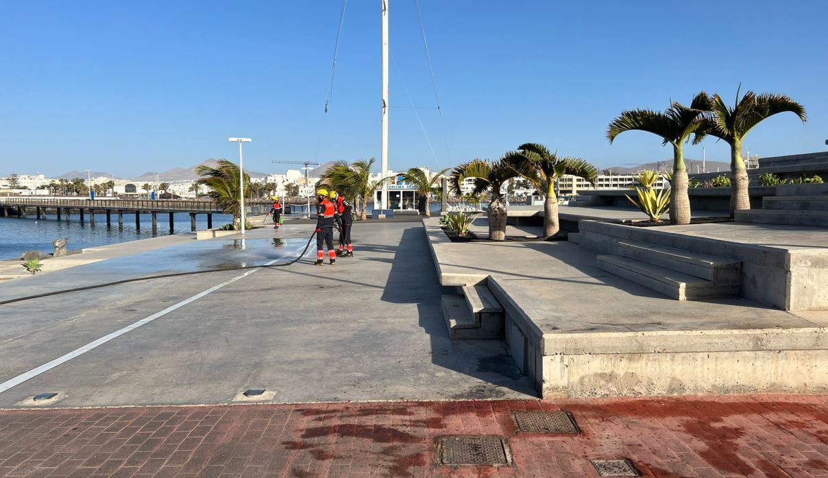 Los bomberos limpian las manchas de sangre de Marina Lanzarote donde se produjo la reyerta