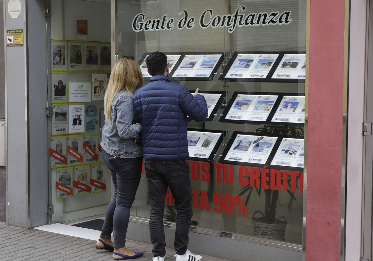 Pareja buscando vivienda en una agencia inmobiliaria