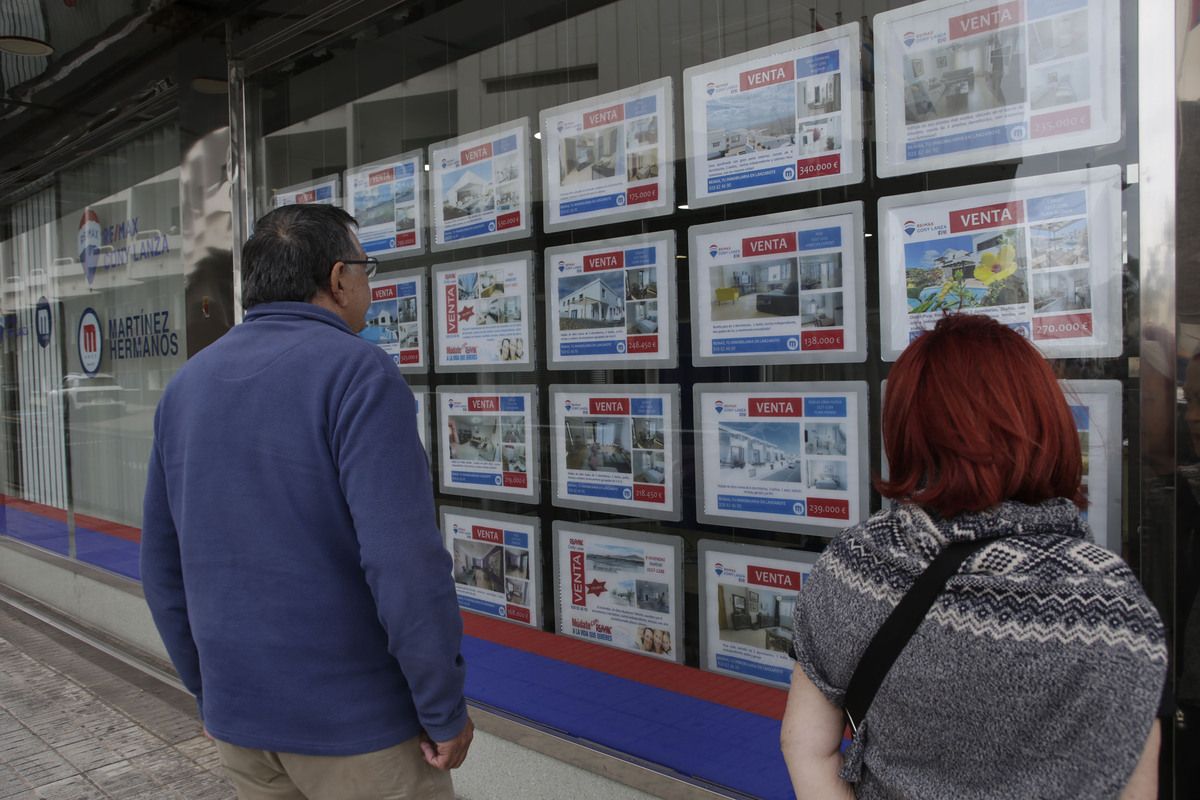 Personas mirando las ofertas en una agencia inmobiliaria