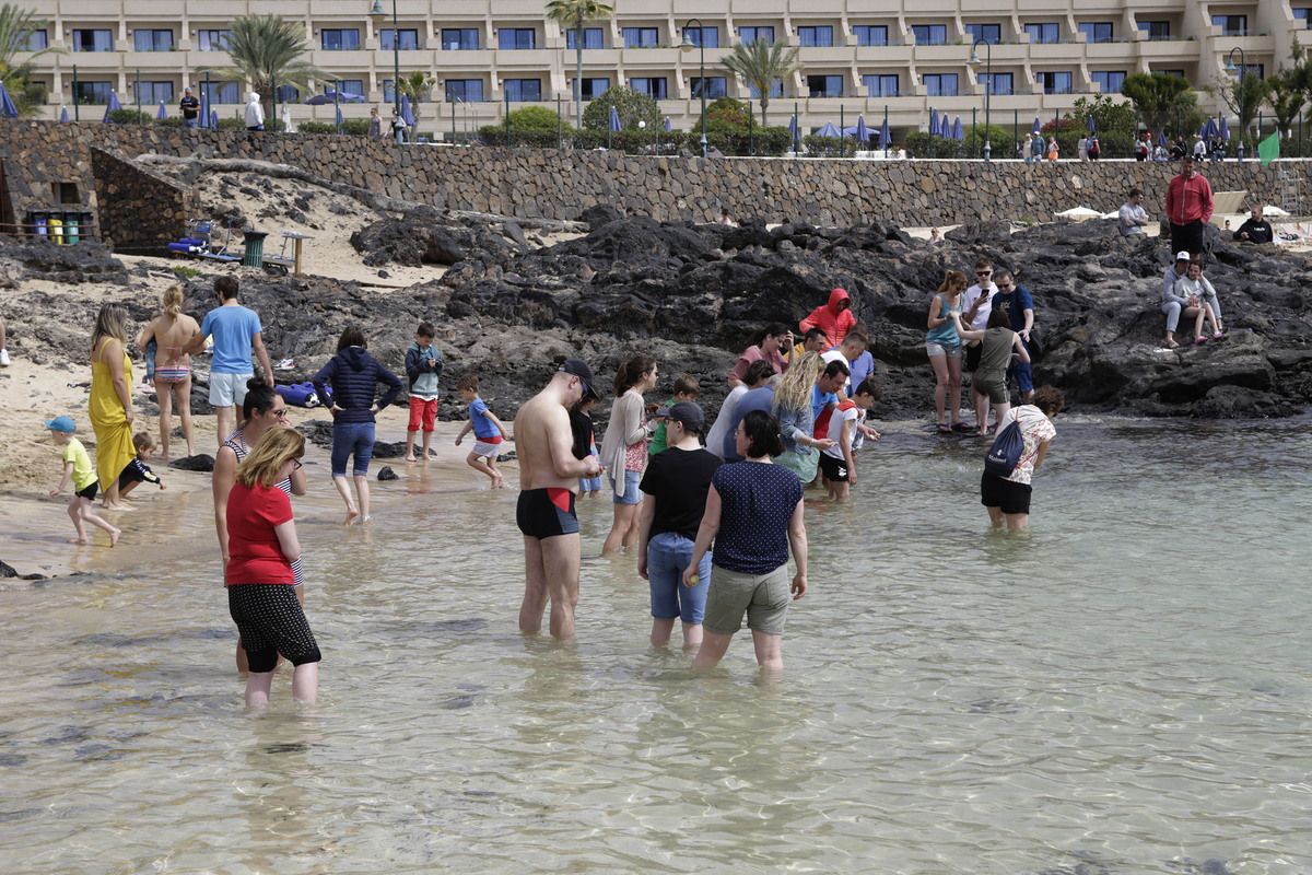 Turistas metidos en la playa de Costa Teguise