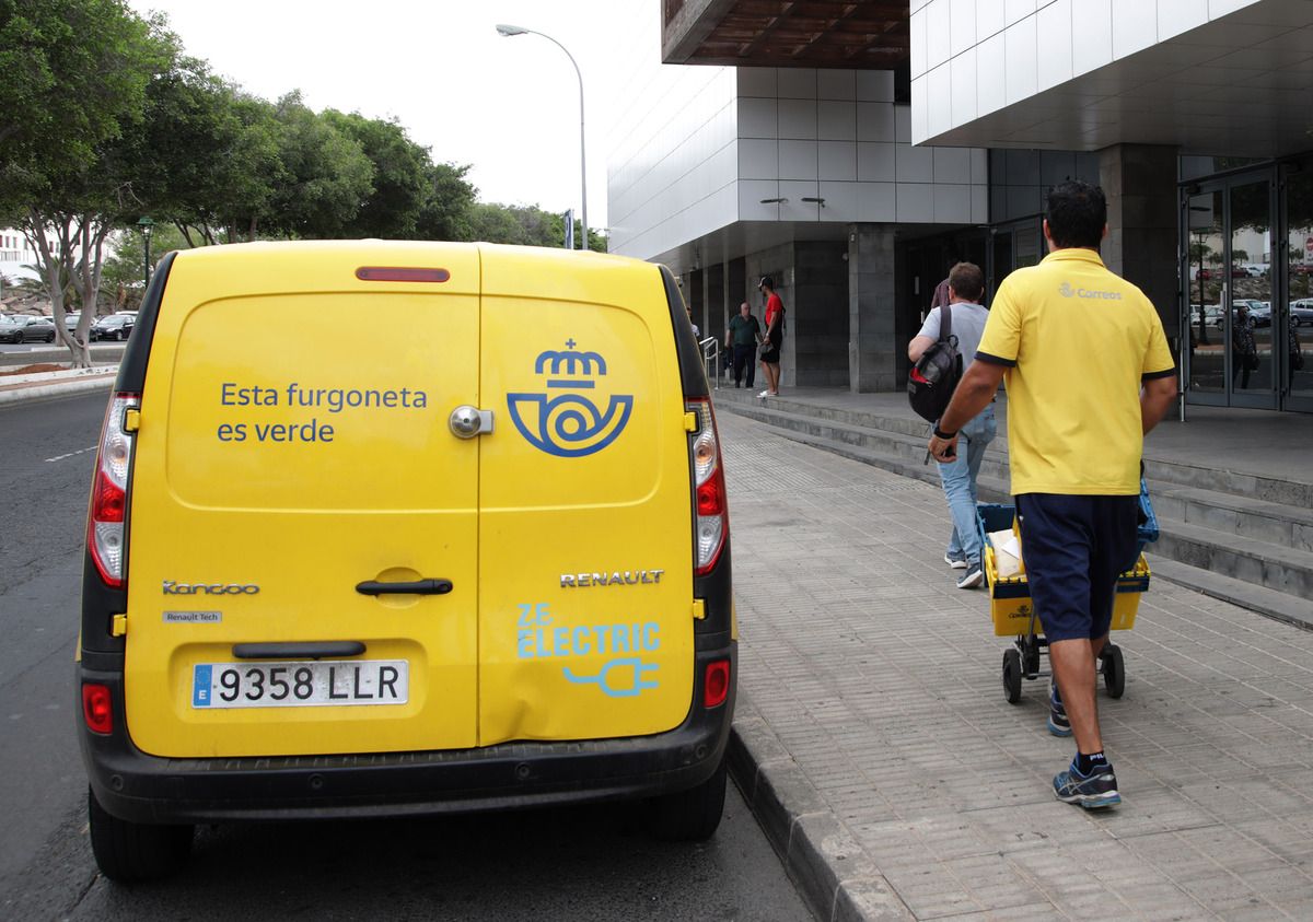 Trabajador de Correos con paquetes en reparto