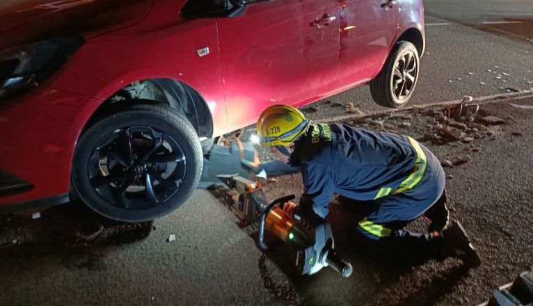 Los bomberos sacando la farola bajo el vehículo