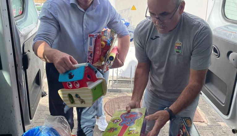 El alcalde junto a un trabajador municipal trasladando los juguetes 