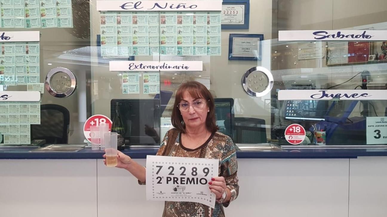 Saro Martín, con el cartel del Segundo Premio de la Lotería del Niño, en la administración del Deiland. Fotos: LaProvincia