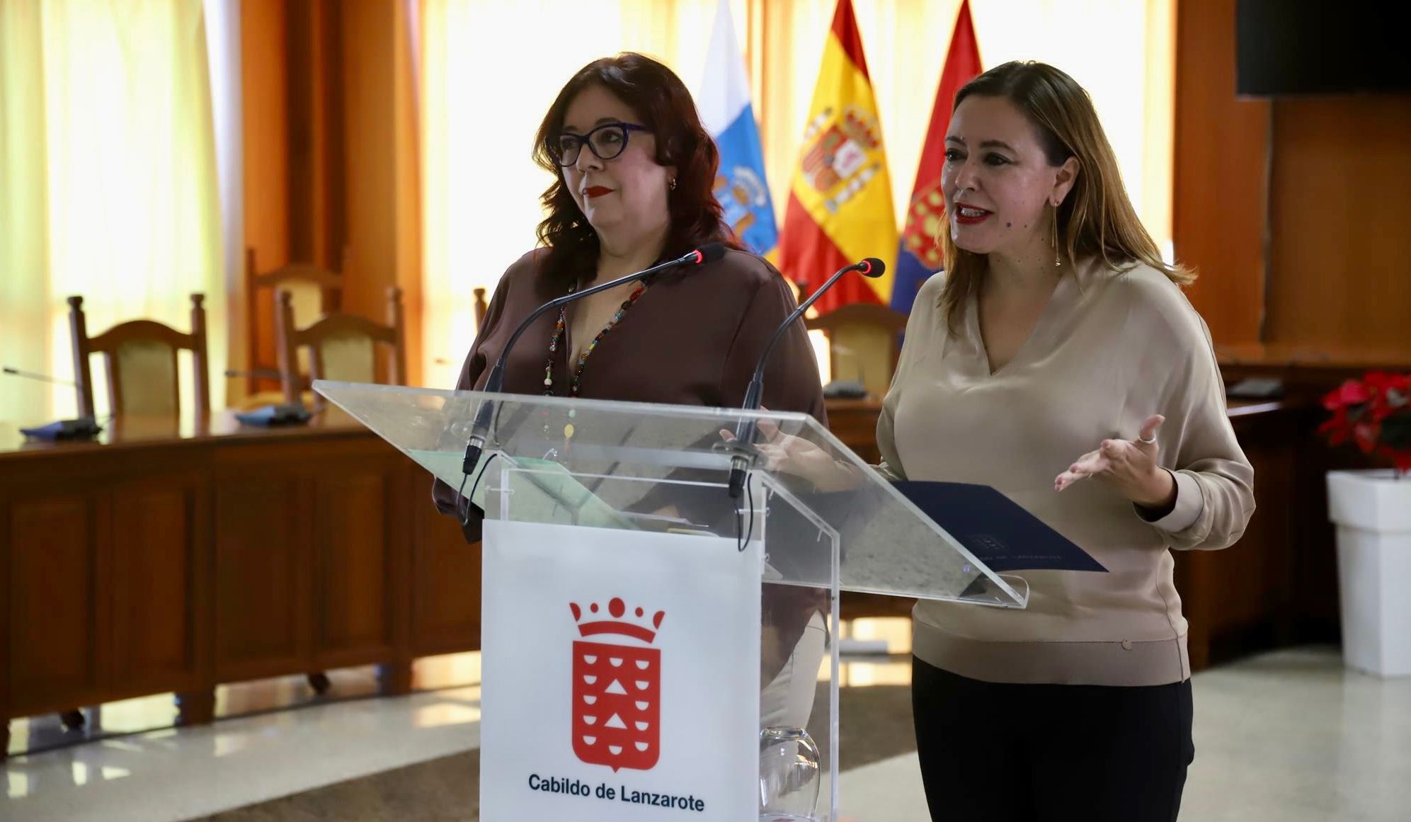 La presidenta del Cabildo de Lanzarote, María Dolores Corujo (d) y la consejera de Educación, Universidades, Cultura y Deportes del Gobierno de Canarias, Manuela Armas (i)