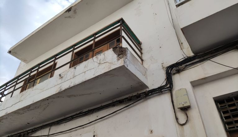 Balcón de una vivienda con barras de hierro y revestimiento de hormigón en mal estado