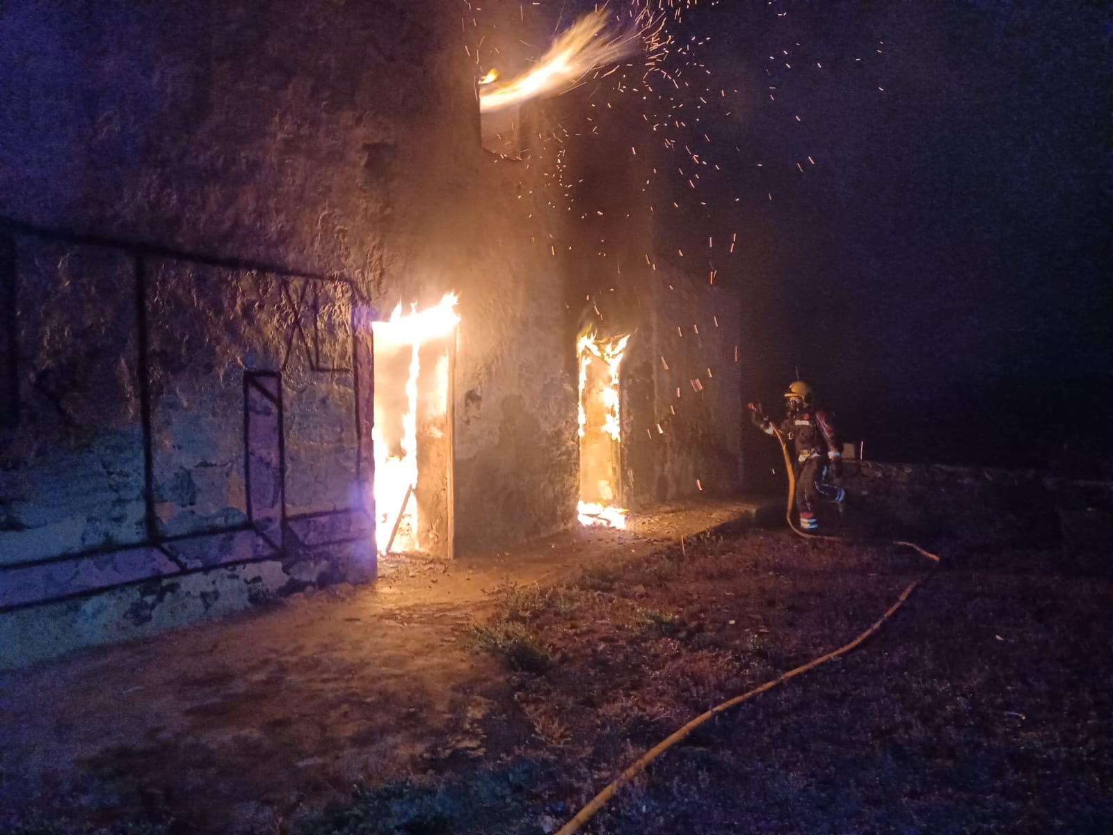 Bombero sofocando el incendio en la vivienda abandonada
