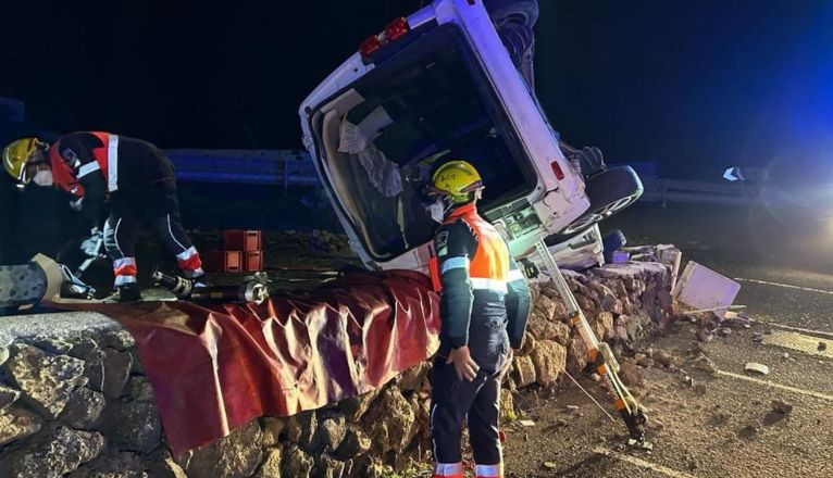 Los bomberos junto al vehñiculo accidentado