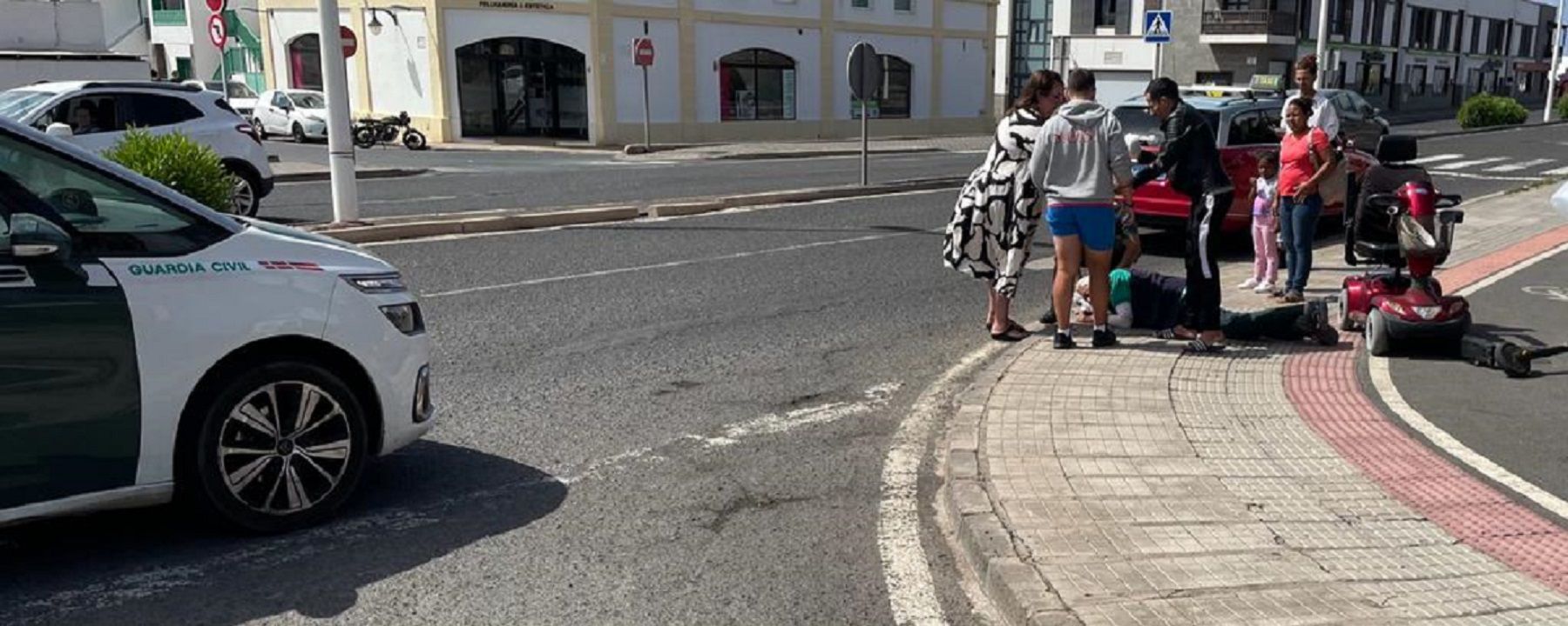 El herido en el suelo tras colisionar contra un patinete en la estación de guaguas de Playa Blanca