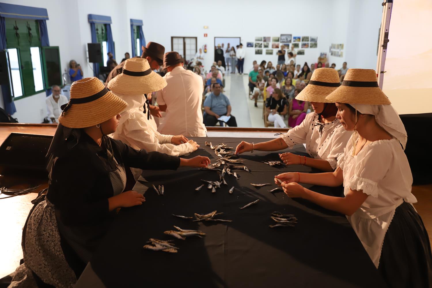 Varias mujeres representan el trabajo de las conserveras, ataviadas con la vestimenta típica de campesina. 