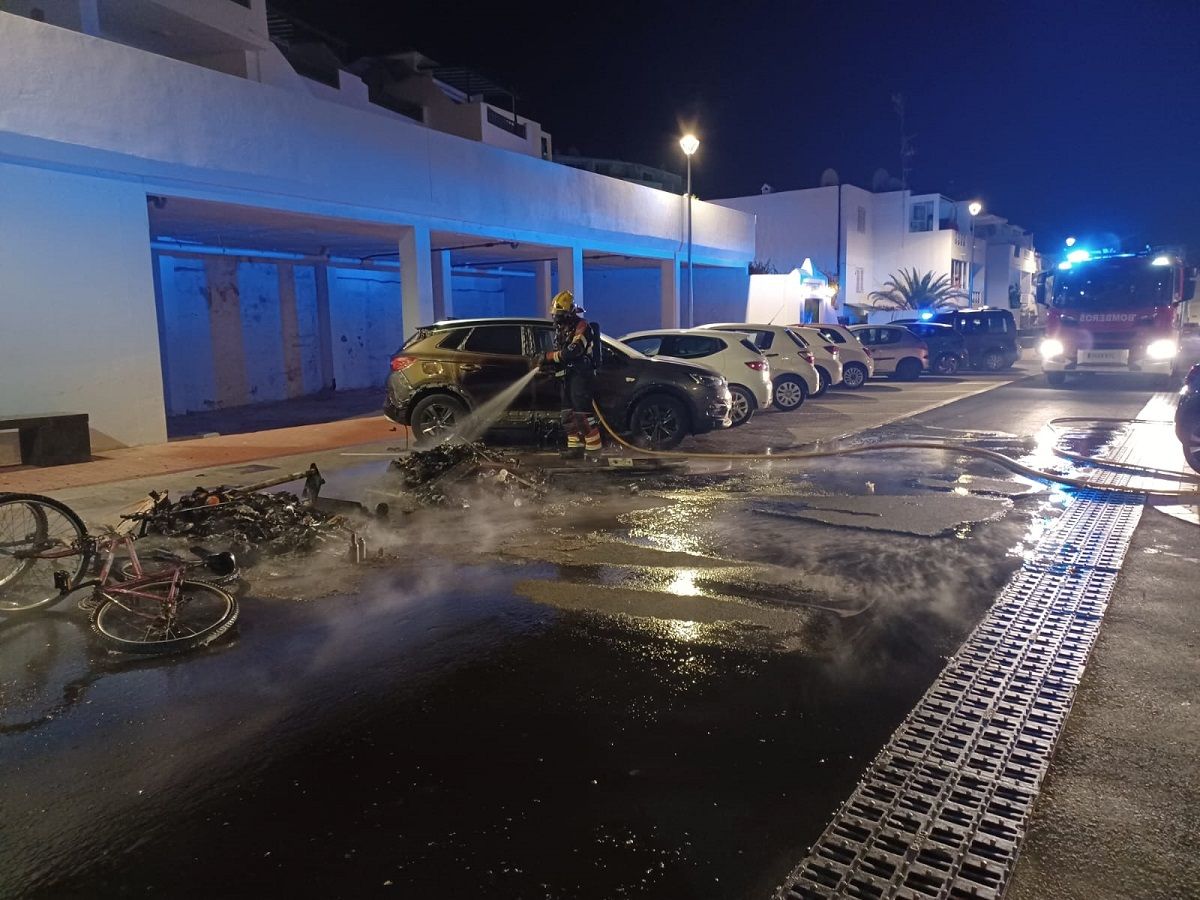 Los bomberos apagando el incendio en dos contenedores en Puerto del Carmen