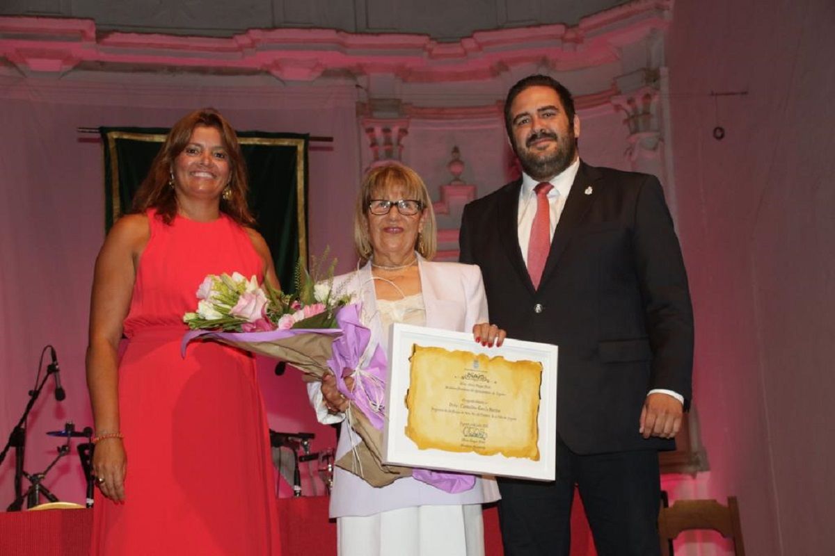 Olivia Duque y Francisco Javier Díaz entregándole un ramo de flores a la pregonera Carmelina García Barrios