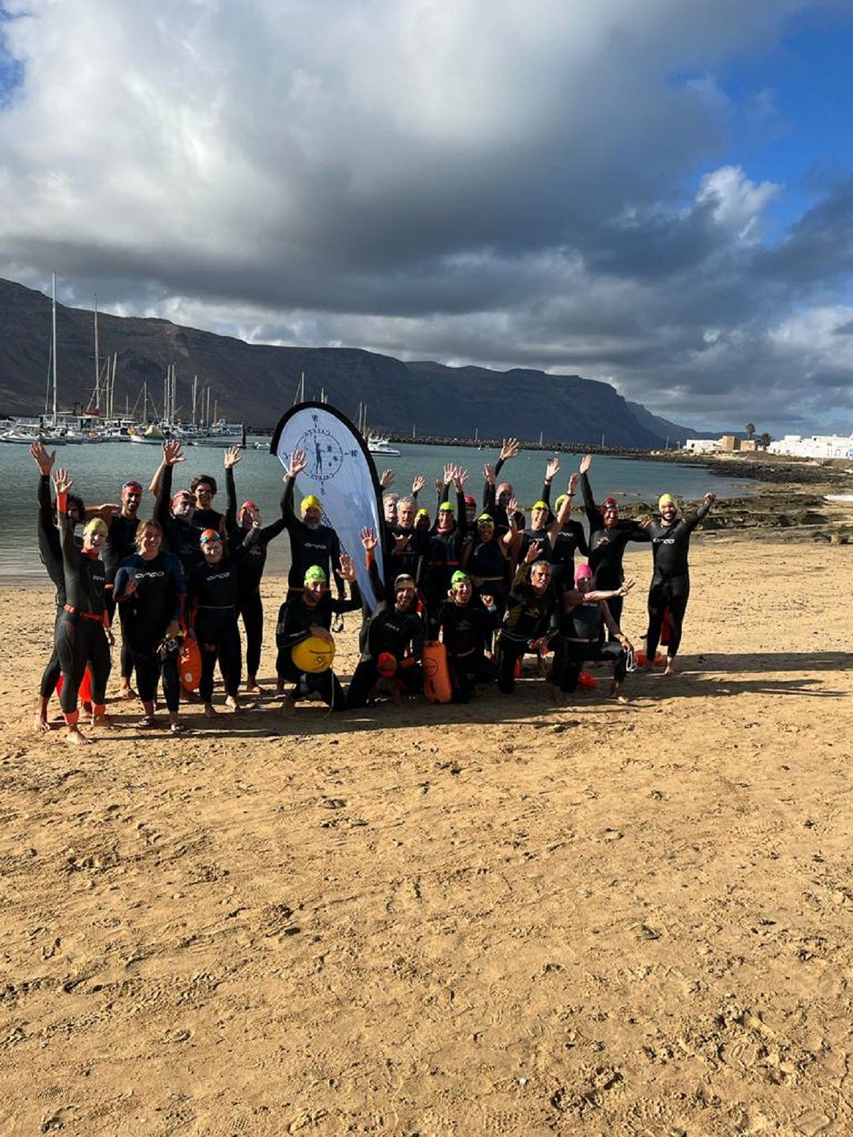 Los nadadores de la Travesía a nado 'Caleta-Caleta' en la playa del pueblo de Caleta Famara