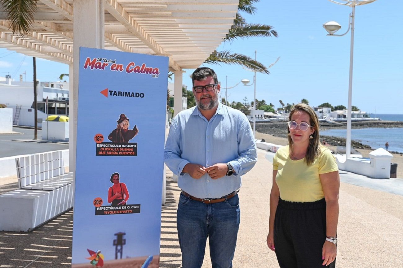 Isidro Pérez next to the 'Mar en Calma' festival poster in Playa Honda