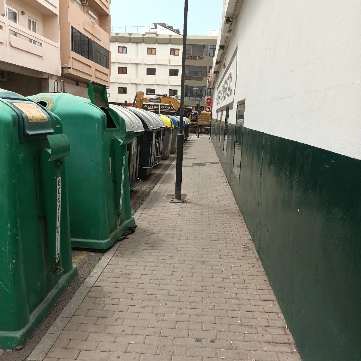 Los contenedores de basura frente al comercio en la calle Peñas del Cache