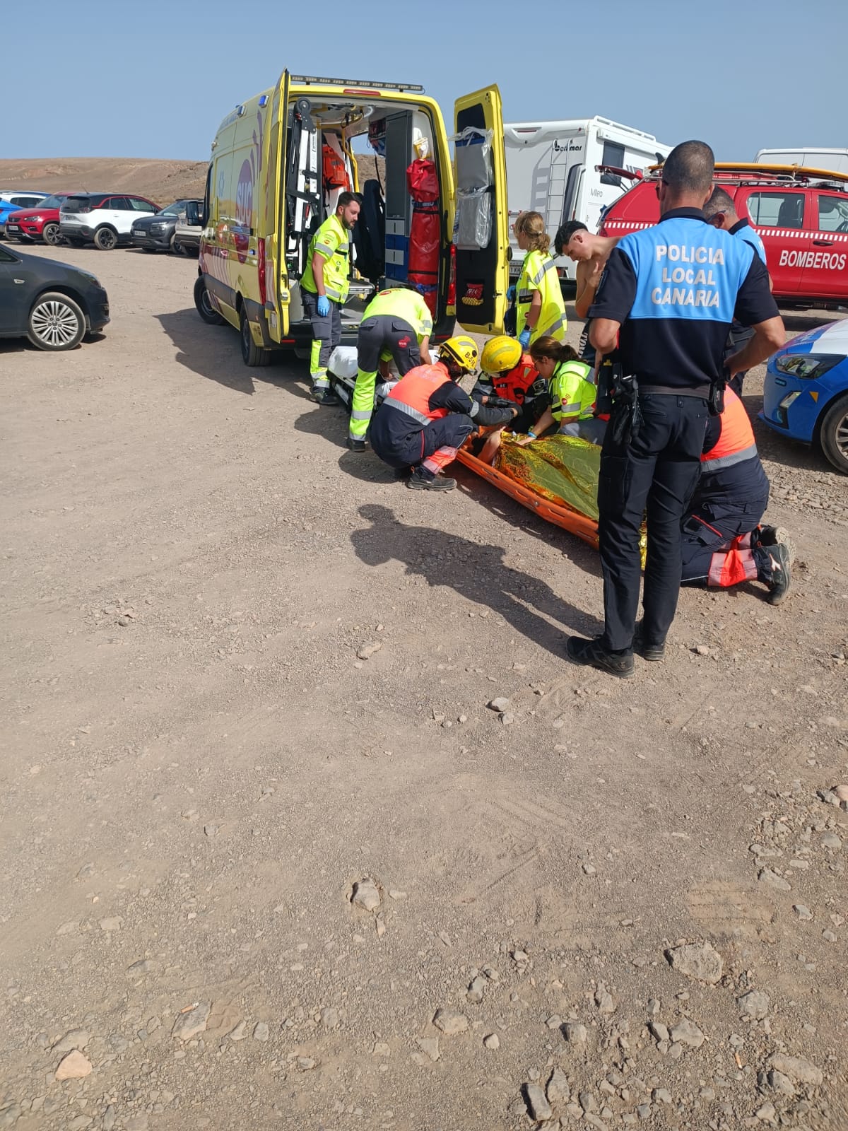 Los bomberos, la Policía Local y los sanitarios atienden a la mujer accidentada en la playa Mujeres. Foto: Bomberos de Lanzarote.