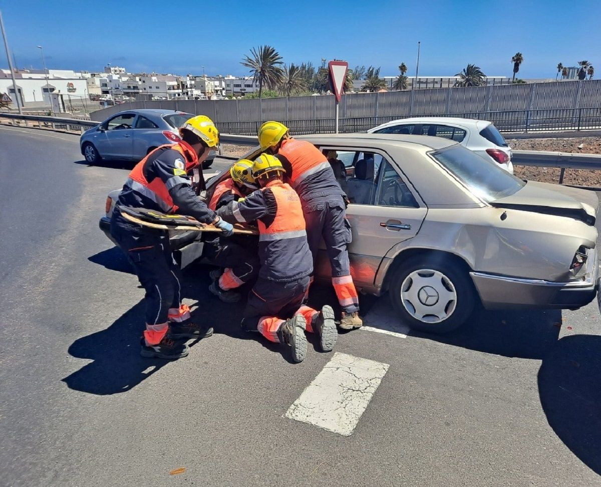 Los bomberos sacando a uno de los heridos del interior del coche