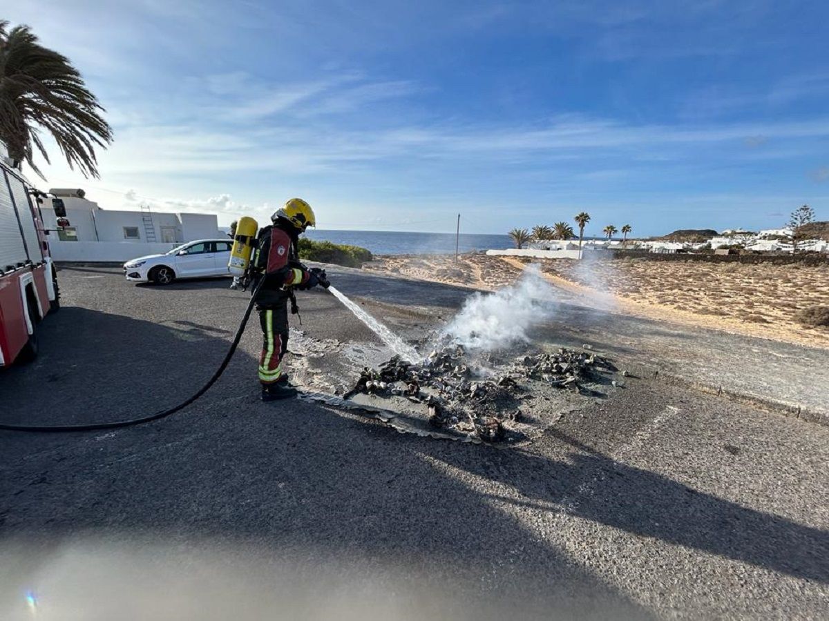 Los bomberos apagando el incendio de contenedores en Charco del Palo