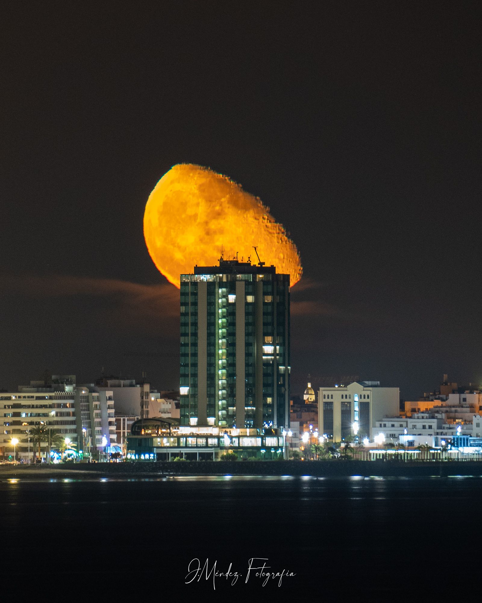 La luna tras el Gran Hotel de Arrecife. Foto: Juan Méndez @j.mendez.fotografía