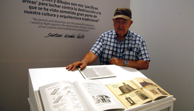 El pintor y dibujante Santiago Alemán posa junto a sus obras en la exposición 'Contra el Olvido'