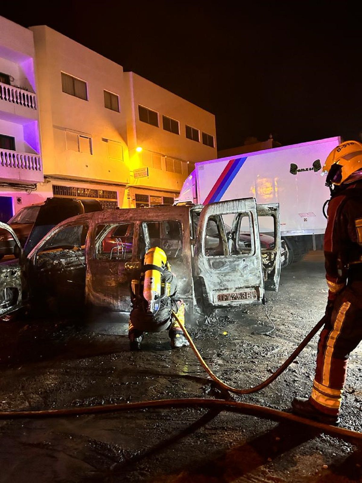 Los bomberos en la zona tratando de apagar las llamas de los vehículos