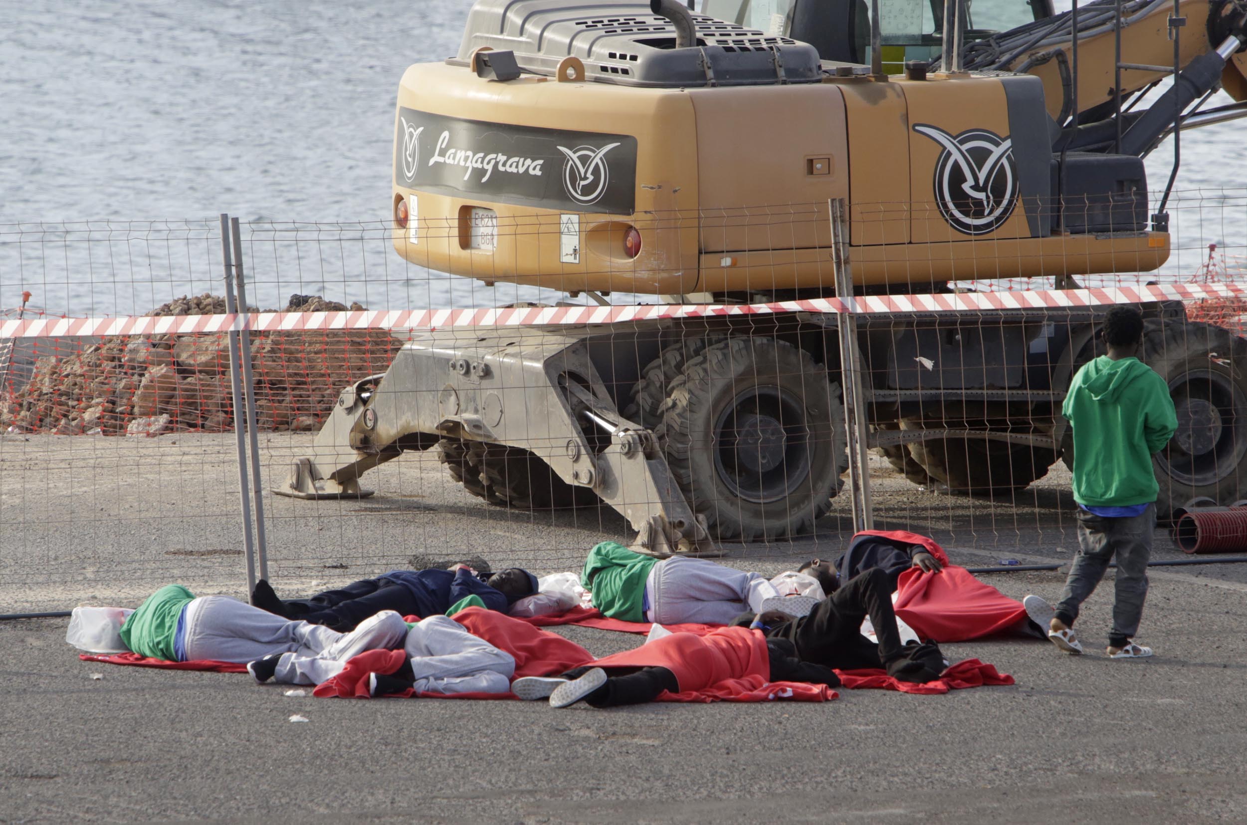 Varias personas migrantes duermen en el suelo del muelle de Puerto Naos ante la falta de recursos. Foto: José Luis Carrasco.