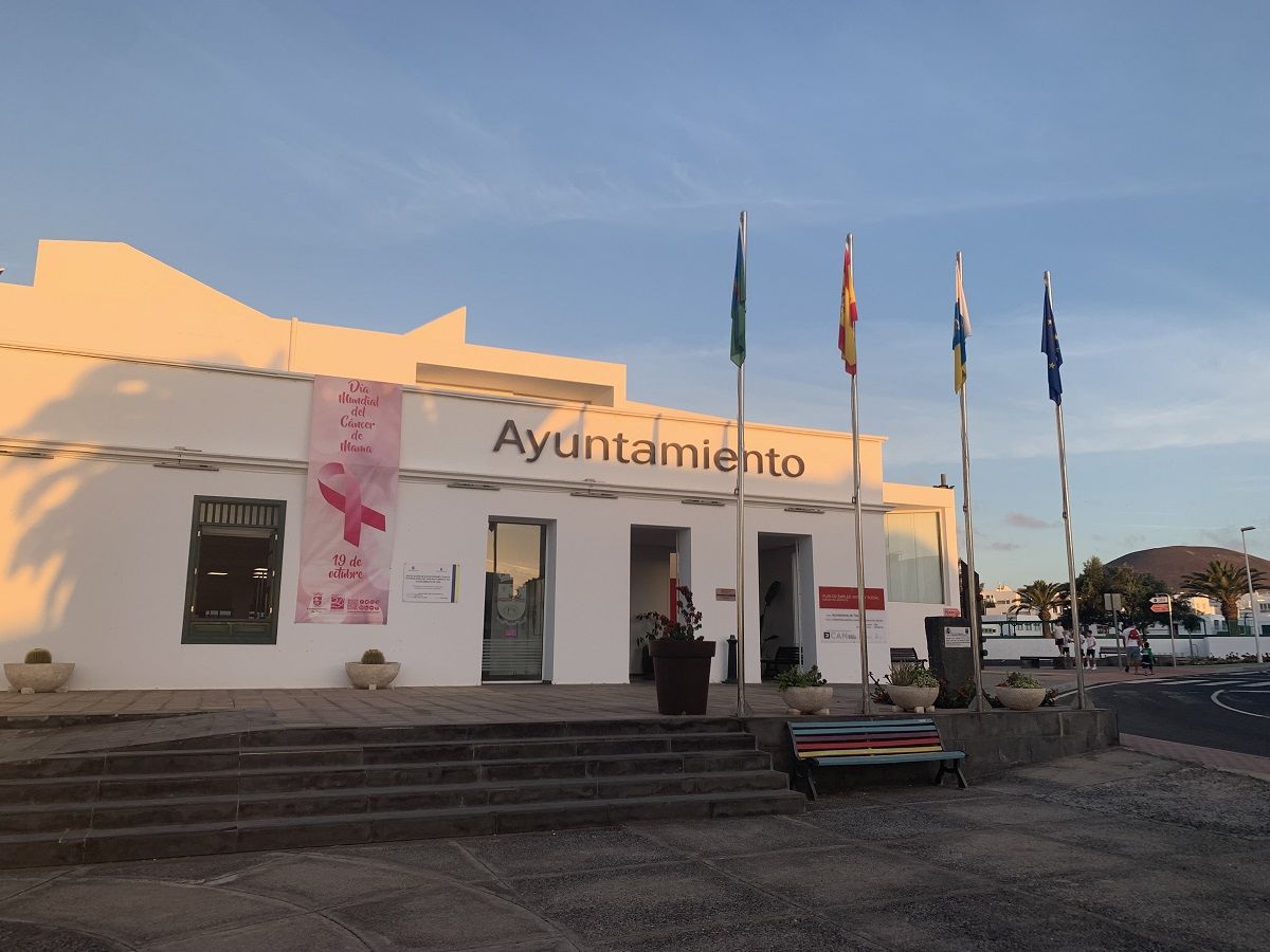 La fachada del Ayuntamiento de Tías con una lona rosa por el día mundial 