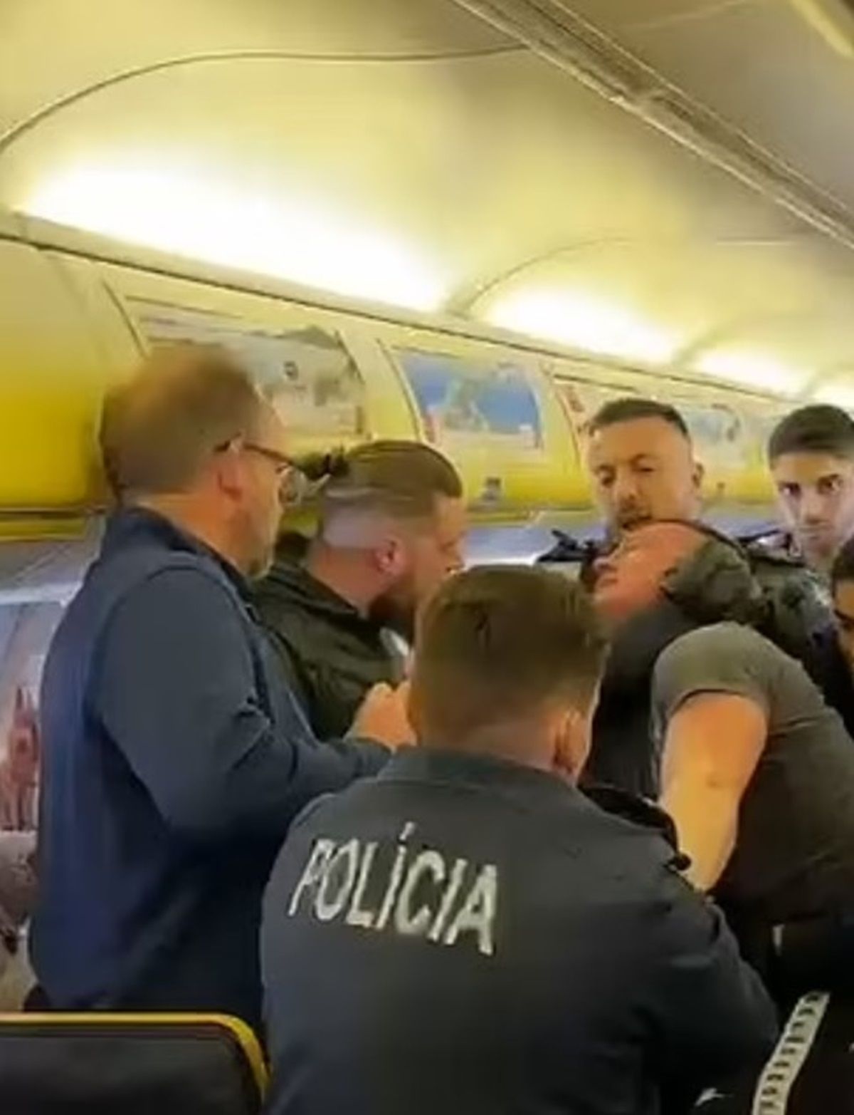 La policía agarrando a uno de los pasajeros en el avión (Foto: Daily Mail)