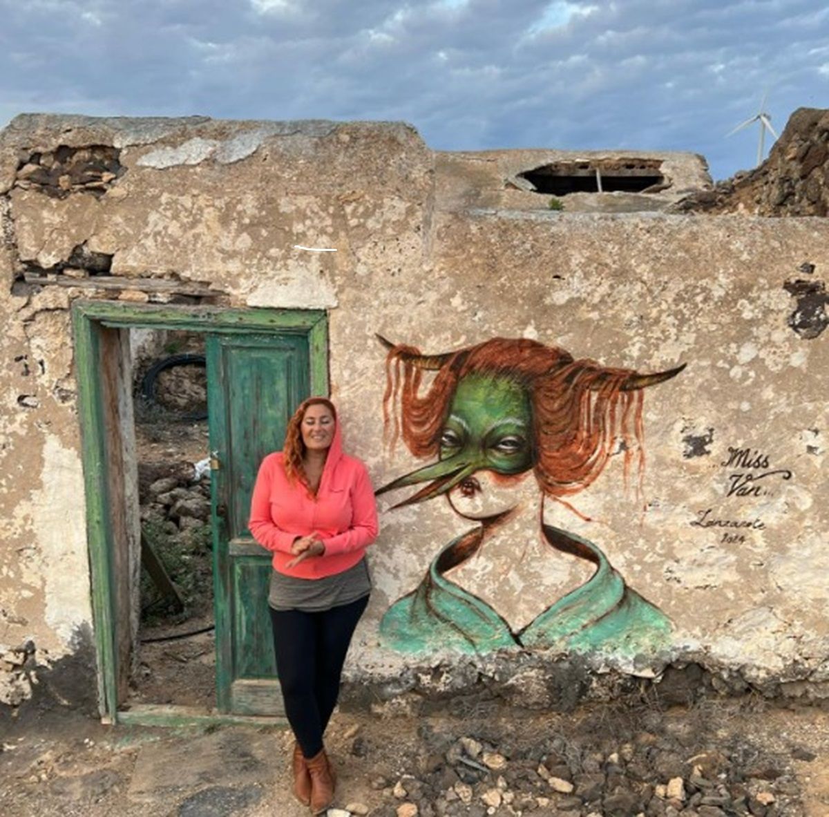 La turista junto a las pintadas en una casa en ruinas