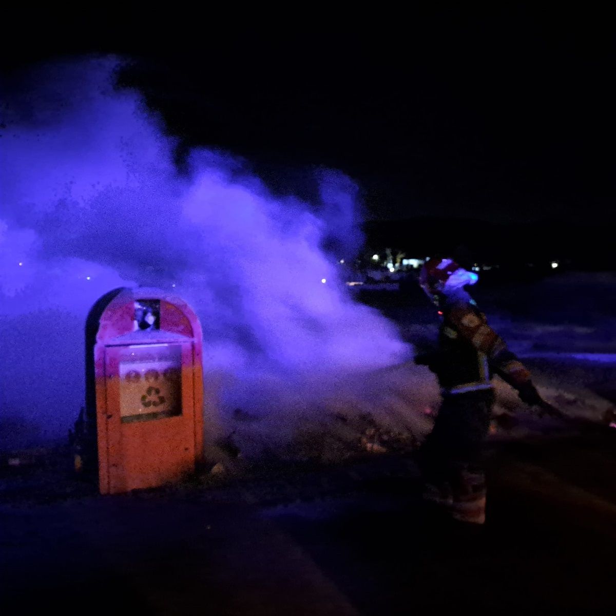 Los bomberos apagando el fuego de los contenedores